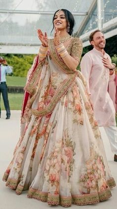 a woman in a white and pink lehenga dancing