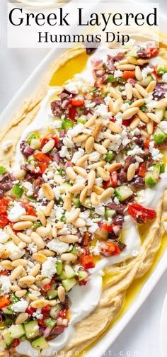 greek layered hummus dip on a white platter