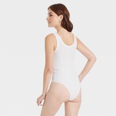 Update your wardrobe with the Double-Scoop Bodysuit from A New Day™. This sleeveless bodysuit is made of a soft fabric blend with added spandex for a comfortable fit that moves with you as you go about your day, while its solid-hued silhouette with allover ribbing offers textural dimension to your look. The pullover bodysuit has a scoop neckline at the front and back with reinforced stitched detailing on top and around the arm holes for some extra flair. White Sleeveless Seamless Bodysuit, Spring Elastane Bodysuit For Loungewear, Fitted White Tank Bodysuit, White Fitted Tank Bodysuit, High Stretch Sleeveless Bodysuit For Loungewear, Casual Elastane Bodysuit For Loungewear, White Sleeveless Bodysuit For Loungewear, Sleeveless Cotton Bodysuit For Loungewear, Sleeveless Leotard With Seamless Construction