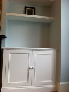 an empty white cabinet in the corner of a room