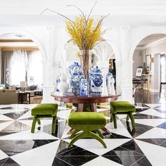 a dining room with black and white flooring and blue vases on the table