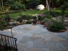 a stone patio surrounded by lush green trees