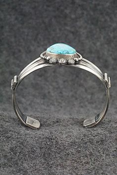 This natural Kingman turquoise and sterling silver bracelet was made by Navajo silversmith Michael Calladitto. The inside is signed MC and stamped Sterling.Size: 5 3/4" (will fit up to a 6 7/8" wrist)Gap: 1 1/8"Width: 1 3/4"Cuff Width: 5/8"Free shipping on all orders! We ship with USPS and always include tracking. All orders ship within a day of payment.Returns are accepted up to 30 days after you receive your order. Just send us a message. Our shop offers cash back or store credit. The item mus Luxury Southwestern Sterling Silver Bracelet, Southwestern Sterling Silver Bracelet With Turquoise Inlay, Turquoise Sterling Silver Cuff Bracelet With Inlay, Southwestern Turquoise Inlay Sterling Silver Bracelet, Adjustable Hand-tooled Turquoise Cuff Bracelet, Southwestern Silver Hand-strung Bracelets, Kingman Turquoise, Holiday Sales, Turquoise Sterling Silver