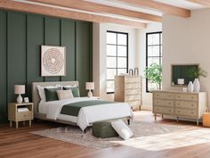 a bedroom with green walls and white bedding, dressers, mirror and chest of drawers