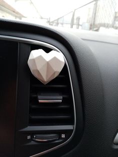 a car air vent with an origami heart on it