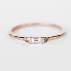 a rose gold ring with two diamonds on it