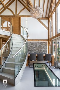 a large open floor plan with stairs and glass railings leading up to the second floor