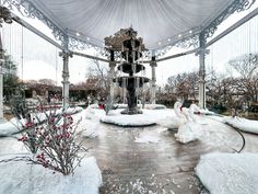 a fountain surrounded by snow in a park