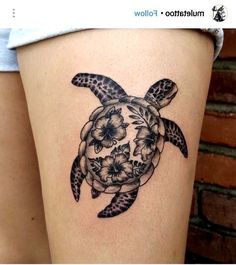 a woman's thigh with a tattoo of a turtle and flowers on the side