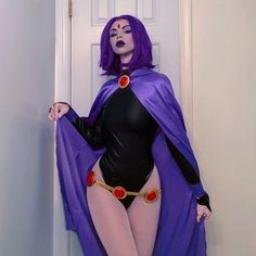 a woman in a purple cape and black bodysuit is standing by a white door