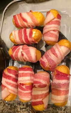 bacon wrapped up in small pieces on top of a glass dish