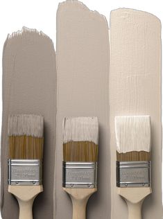 three paintbrushes with different shades of white and beige on them, one is brown