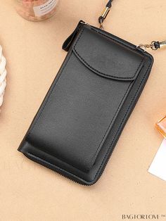 a black leather wallet sitting on top of a table next to a bottle of perfume