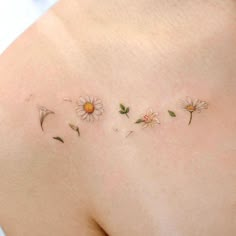 the back of a woman's shoulder with daisies on it