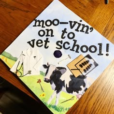 a decorated cap that says moo - win on to vet school with cows and clothes