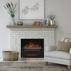 a living room with a fire place in the center and a chair next to it