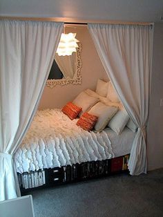 a bed with white sheets and pillows in front of a mirror