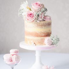 there is a cake with flowers on the top and two small cakes next to it