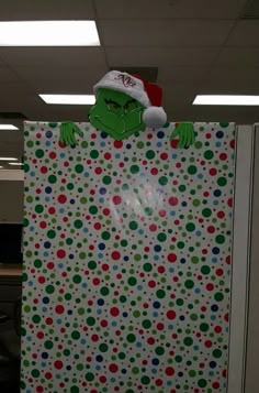 an office cubicle decorated for christmas with the grin face on it's door