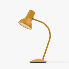 a yellow desk lamp sitting on top of a table