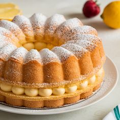 a bundt cake with lemons and powdered sugar on top sits on a plate