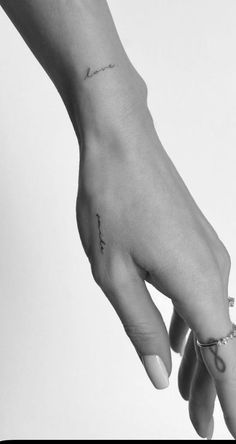 a woman's hand with a small tattoo on it