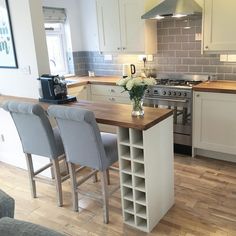 a kitchen filled with lots of counter top space and chairs next to a stove top oven