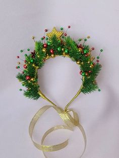 a green and gold christmas wreath on top of a ribbon