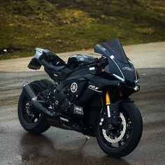 a black motorcycle parked on top of a wet road