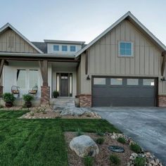 a large house with two car garages in the front yard and grass on the side