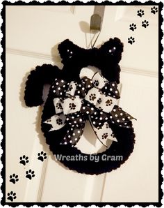 a black and white minnie mouse wreath hanging on a door with paw prints around it