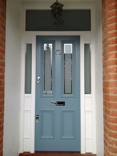 a blue front door with white trim and brick pillars