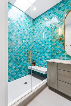 a bathroom with blue and green tiles on the walls