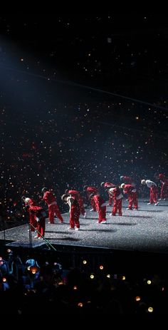 a group of people standing on top of a stage in the middle of a crowd