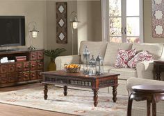 a living room filled with furniture and a flat screen tv on top of a wooden table