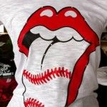 a t - shirt with the rolling stones on it's chest and baseball in its mouth