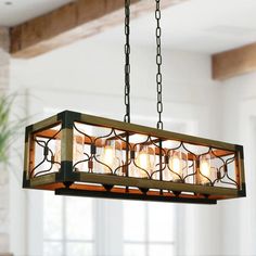 a chandelier hanging from the ceiling in a room with windows and potted plant