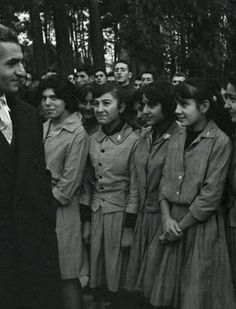 black and white photograph of man standing in front of group of young women wearing dress clothes