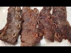 three pieces of meat sitting on top of a white plate