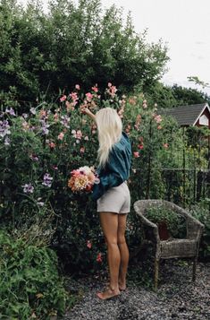 a woman standing in front of some flowers