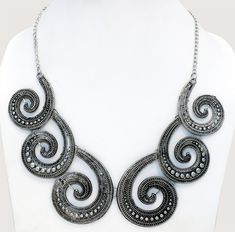 Six engraved silver metal alloy spiral in a vintage oxidized old world look., bound together by metal hooks to create a uniquely handcrafted masterpiece. An urban fashion look for any age, necklace design is a modern look. It closes with a lobster claw clasp at the back. It`s a great accouterment to any of your modern fashion dresses or tops. Silver Spiral Metal Necklaces, Adjustable Spiral Jewelry With Oxidized Finish, Adjustable Silver Necklace With Antique Finish, Silver Spiral Metal Necklace, Silver Spiral Bohemian Necklace, Spiral Metal Jewelry With Oxidized Finish, Bohemian Silver Spiral Necklace, Handmade Vintage Spiral Jewelry, Bohemian Spiral Metal Necklace