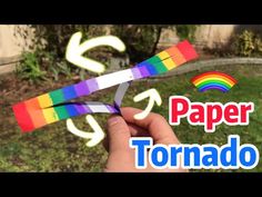 someone is holding up some paper scissors in front of a rainbow colored arrow and the words paper tornado