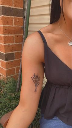 a woman with a flower tattoo on her left arm and right arm behind her back