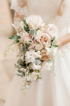 a bridal holding a bouquet of flowers and greenery