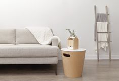 a white couch sitting next to a table on top of a hard wood floor