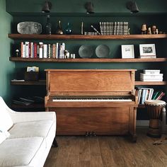 a living room filled with furniture and a piano in front of a bookshelf