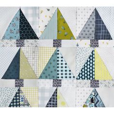 a close up of a quilt with many different colored triangles on the front and back