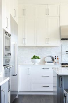 a kitchen with white cabinets and stainless steel appliances