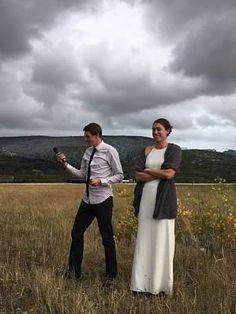 a man and woman standing in the middle of a field