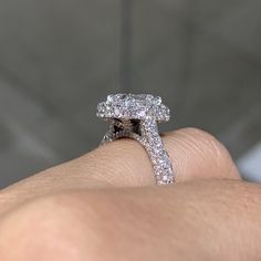 a close up of a person's hand with a diamond ring on their finger